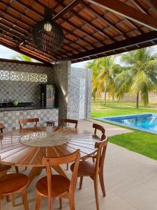 a patio with a table and chairs and a pool at Sítio Sossego - a 5 min da Praia das Fontes in Beberibe +23 photos
