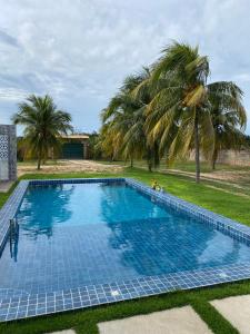 an overhead view of a swimming pool with palm trees at Sítio Sossego - a 5 min da Praia das Fontes in Beberibe