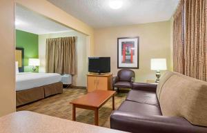 ミドルバーグ・ハイツにあるExtended Stay America Suites - Cleveland - Middleburg Heightsのベッド、ソファ、テレビが備わるホテルルームです。