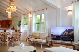 uma sala de estar com uma televisão de ecrã plano sobre uma mesa em Blue Whale Villa - Penthouse em Calibishie