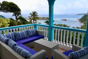 a balcony with chairs and a view of the ocean at Blue Whale Villa - Penthouse in Calibishie