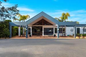 un edificio con techo azul y palmeras en Comfort Inn & Suites Riverland en Barmera