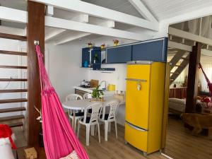 a kitchen with a yellow refrigerator and a table at Casa América in Parnaíba