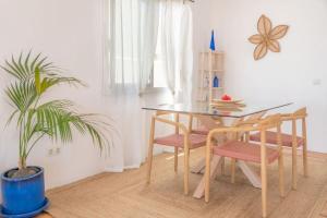 CocoMar I- Luxurious villa with heated pool near the sea في Guatiza: غرفة طعام مع طاولة وكراسي ومصنع +51 صورة