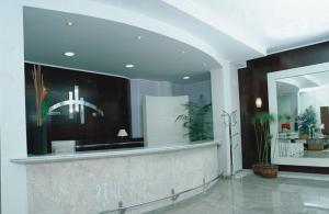 a lobby with a reception counter and a mirror at Hotel Metrópolis in Sao Jose do Rio Preto