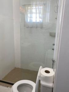 a white bathroom with a toilet and a shower at Casa América in Parnaíba