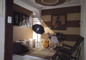 sala de estar con guitarra, mesa y sillas en Casa hotel Mi Huila en Neiva
