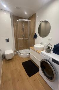 a bathroom with a shower and a washing machine at Apartament w centrum Gdyni in Gdynia