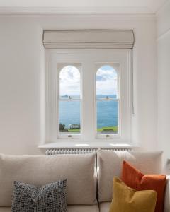a living room with a couch and two windows at FOX ON THE HOE in Plymouth