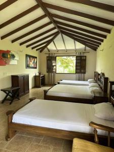 1 dormitorio con 3 camas y techo con vigas. en cabaña completa en la mejor ubicacion del Quindio en Pueblo Tapao