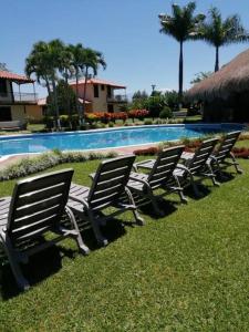 a row of chairs sitting next to a swimming pool at cabaña completa en la mejor ubicacion del Quindio in Pueblo Tapao