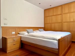 um quarto com uma cama grande e armários de madeira em Apartment Cesa Collina Superior em Ortisei