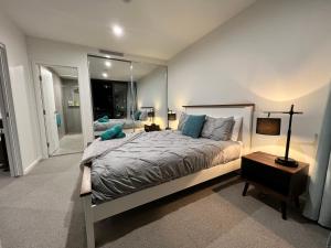 - une chambre avec un lit et un grand miroir dans l'établissement Embark Luxe 2BR 2Bath Apartment in Lynham 1 Secure Carpark Wifi Canberra, à Canberra