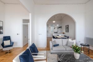 a living room with blue chairs and a couch at FOX ON THE HOE - Luxury Apartment accommodation in Plymouth