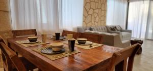 a wooden table with cups and plates on it in a living room at Kin Tulum House downtown in Tulum