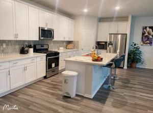 a large kitchen with white cabinets and a counter top at One -Story House With 3 Rooms in Riverside