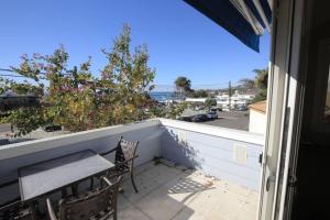 a balcony with a table and chairs and a view of the ocean at Laguna Beach Modern Home-beach across st/town 1blk in Laguna Beach
