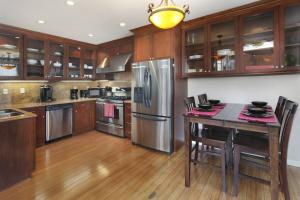 a kitchen with wooden cabinets and a stainless steel refrigerator at Laguna Beach Modern Home-beach across st/town 1blk in Laguna Beach