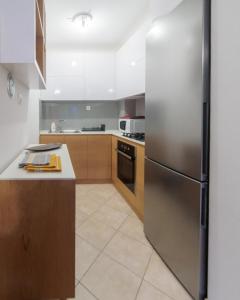 una cucina con frigorifero in acciaio inossidabile di City Center Family Apartment Novi Sad a Novi Sad