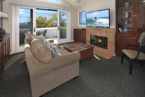 sala de estar con sofá y chimenea en Laguna Beach Modern Home-beach across st/town 1blk en Laguna Beach