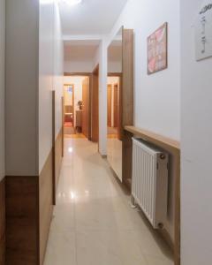 un corridoio in un edificio con pareti bianche e radiatore di City Center Family Apartment Novi Sad a Novi Sad
