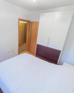 un grande letto bianco in una stanza con porta di City Center Family Apartment Novi Sad a Novi Sad