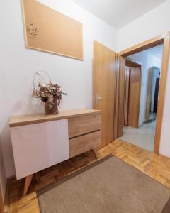 a room with a dresser with a potted plant on it at City Center Family Apartment Novi Sad in Novi Sad