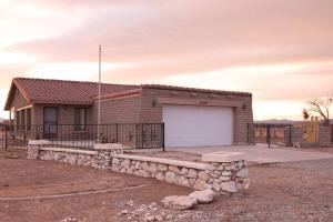 a brick building with a white garage door and two benches at Cozy Adobe in Pahrump