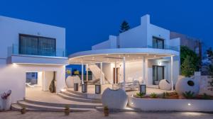 Una casa blanca con escaleras delante por la noche en Mika Villas & Suites, en Hersonissos