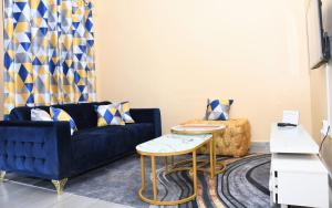 a living room with a blue couch and a table at Intellicents Apartments in Kisumu