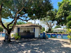 a small white house with a tree in front at Linda Casa na Penha ! in Vera Cruz de Itaparica