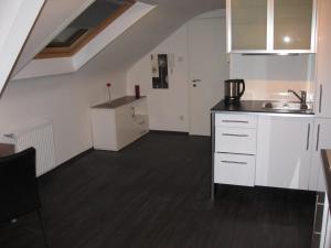 eine Küche mit weißen Schränken und einem Waschbecken in der Unterkunft Apartment in Mönchengladbach