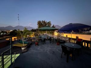 un patio con mesas, sillas y sombrillas en Orkkowasi backpackers en Arequipa