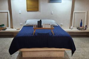 - un lit avec une couverture bleue et une table dans l'établissement Suite Stella Maris en el Centro Histórico Carmen, à Ciudad del Carmen