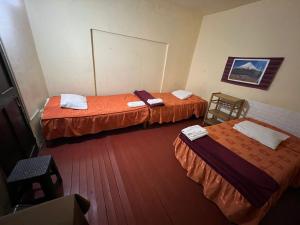 a hotel room with two beds and a table at Orkkowasi backpackers in Arequipa