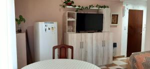 uma sala de estar com uma televisão e um frigorífico em Puñadito de descanso em Salta