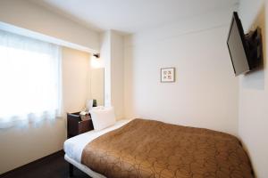 a hotel room with a bed and a television at Hotel Kyoto Base in Kyoto