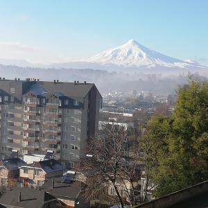 vistas a una montaña nevada desde una ciudad en Villarrica Mirador Apartment, en Villarrica
