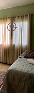 um quarto com uma cama e uma janela com cortinas em Hostel Portal da Montanha em Blumenau