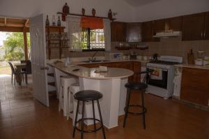 a kitchen with a counter and stools in it at Villa Rosandri in Bayahibe