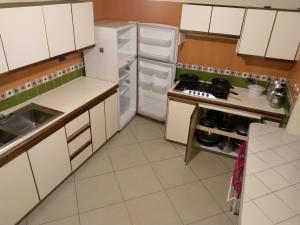 a kitchen with white cabinets and a stove and refrigerator at Finca Andalucia con Piscina en Mesitas in El Colegio