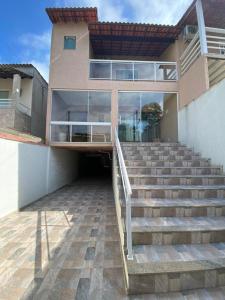 ein Gebäude mit einer Treppe vor einem Gebäude in der Unterkunft Aconchego casa para temporada in São Pedro da Aldeia