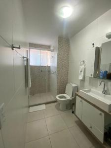 ein Bad mit einer Dusche, einem WC und einem Waschbecken in der Unterkunft Aconchego casa para temporada in São Pedro da Aldeia