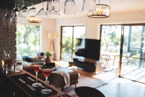 dos copas de vino sentadas en un bar en una sala de estar en High Grange Luxury Mountain Retreat - Pool, Spa, Sauna en Kalorama