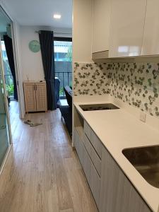 a kitchen with white counters and a wooden floor at The Marvest Hua Hin in Hua Hin