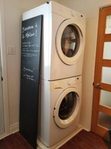 a washer and dryer in a room with a sign at Logement avec stationnement tennis et piscine in Saguenay