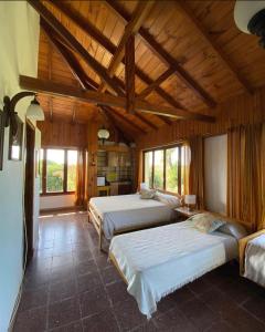 1 dormitorio con 3 camas en una habitación con techos de madera en BQS House en Miramar
