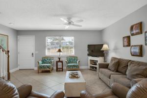 a living room with a couch and a tv at Seabreeze Escape in Destin