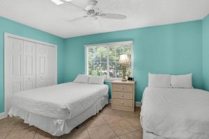 two beds in a room with blue walls and a window at Seabreeze Escape in Destin +40 photos