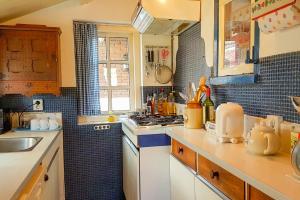 a kitchen with a sink and a stove top oven at Countryside Bliss: Historic Cottage by the Sea in Burgh Haamstede